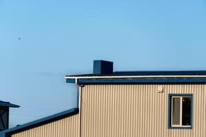 Minimalist Low-Angle View of an Industrial Building Exterior With Corrugated Metal Siding and Azure Sky photo
