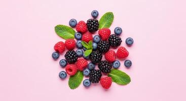 Flat lay of assorted fresh berries and mint leaves scattered on a light textured background photo