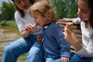 Family Enjoying Ice Cream Together Outdoors in a Park Setting photo