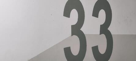 Graphic Composition of Number Thirty-Three on Textured White and Gray Surface photo