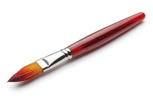 New paint brush with red handle resting on white background photo