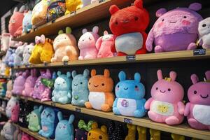 Rows of colorful plushies waiting on shelves in toy store photo