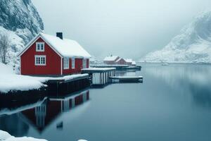 Red wooden houses reflecting on calm water in winter photo