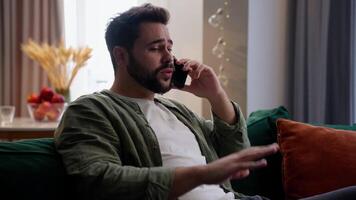 Emotional satisfied happy Caucasian business man male guy client homeowner businessman user chatting mobile phone smartphone conversation call talk friends feedback gesturing hands at home living room video