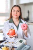 A nutritionist discusses the benefits of fresh fruits such as apples and the dangers of sugar and baked goods for metabolism and the risk of diseases. The concept of dietetics and fitness. photo
