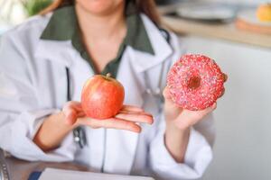 A doctor explains the effect of sweets on human health and the connection with diseases and the benefits of fresh fruits. The concept of dietetics and medical services. photo