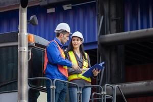 Inspectors team standing on top of a container handlers machine at container yard, Engineer and foreman worker inspecting containers box at shipping yard photo