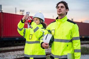 Engineers Inspecting Freight Operations at Rail Yard, Logistics Team on Duty at Industrial Train Terminal, Logistics Team Overseeing Operations by Rail Containers photo