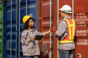Logistics Team Inspecting Shipping Containers at Port, Female and Male Workers Collaborating on Cargo Shipment Inspection, Industrial Port Operations Checking Freight Containers photo