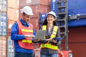 Cheerful engineer and foreman worker team in hardhat and safety vest checking containers box from cargo, Engineers with tablet managing cargo operations, Teamwork concepts photo