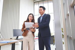 Business Colleagues Reviewing Documents in a Modern Office, Mentorship and Collaboration in a Contemporary Workspace, Professional Man and Woman Discussing Work Paperwork photo