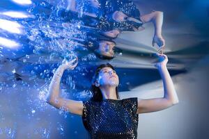 Girl in a Stunning Mermaid Outfit Submerged in Shimmering Water Creating an Enchanting Atmosphere photo
