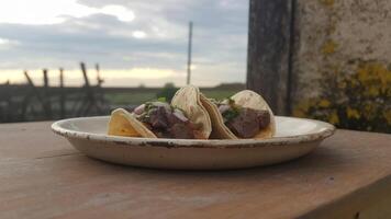 Two tacos on a white plate with a view of the sky photo