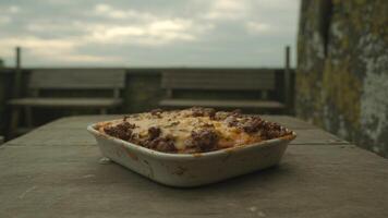 A white dish with meat and cheese photo