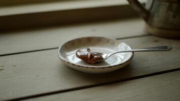 A spoon and a bowl of chocolate on a table photo