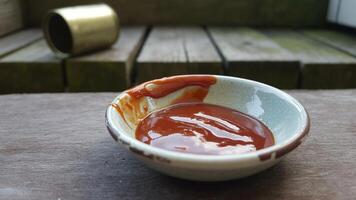 A bowl of sauce sitting on a table photo