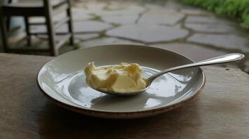 A spoon with butter in a bowl photo