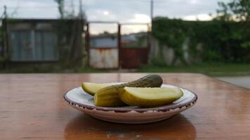 A bowl of pickles on a table in front of a house photo