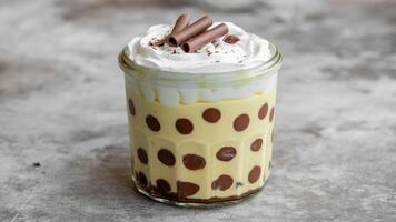 Close up of a chocola te dessert with stra wberry pieces on a white pla te on a neutra l surfa ce photo