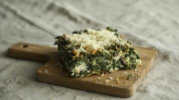 a dish of brea d topped with cheese a nd crea m with a side of toma to sa la d on a wooden ta ble top view photo