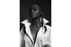 Monochrome portrait of a woman with a shaved head in a white collared shirt photo
