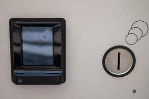 Electronic payment device on a metallic surface, featuring a rectangular black card reader with a screen. photo