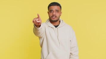 Get out of here. You are fired. Irritated Indian man pointing finger away asking to leave him alone, strict boss firing, conflict, quarrel. Arabian Hindu guy isolated on yellow background indoors video