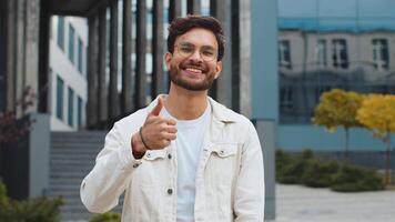 Like. Happy Indian man raises thumbs up agrees with something gives positive reply recommends advertisement likes good idea feedback, celebrating success victory. Arabian guy standing in city street video