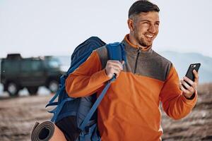 Young caucasian man traveller using his smartphone photo