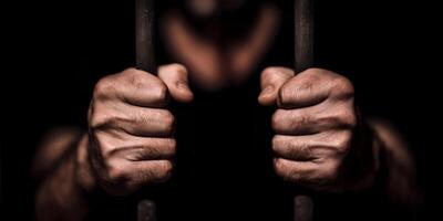 hands behind bars in jail, prison concept photo