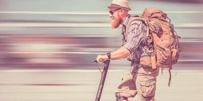 Bearded Man Riding Electric Scooter with Backpack Summer Travel photo