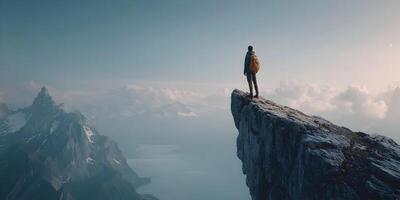 Person standing on mountain top overlooking valley and cloudscape photo