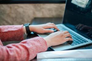 Hands typing on a laptop in a cozy workspace, showcasing modern technology and productivity. photo