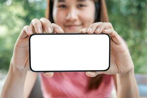 Close-up of a woman holding a smartphone with a blank screen, perfect for mockups and design presentations. photo