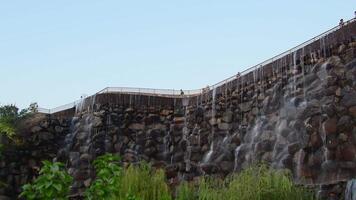 Dushanbe, Tajikistan - 16th november, 2024- Artificial stone waterfall with tourists on upper viewpoint terrace in public Rudaki park, Dushanbe video