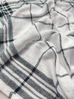 a white and black plaid towel laying on a table photo