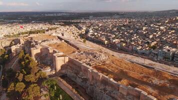 Drone view of historic Urfa Castle with panoramic Sanliurfa cityscape, ancient fortification, Middle East heritage site.Ancient culture video