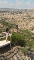 Aerial vertical view Tourist Woman on viewing platform enjoy scenic wild view of Vashlovani National Park cliffs, Georgia semi-desert ecosystem with dramatic erosion canyons and biodiversity video
