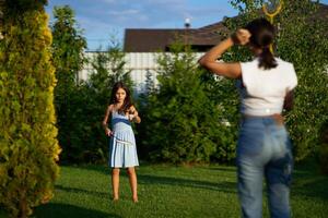 Two girls enjoy a summer afternoon in a grassy backyard, playing with a butterfly net and exploring nature photo