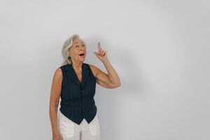 A Senior Woman is Gesturing with Enthusiasm and Joy in a Bright Studio Environment photo