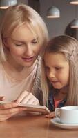 Mother and daughter share a delightful moment over the menu video
