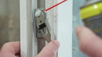 A hand lubricates a door mechanism with a spray can, ensuring smooth door operation video