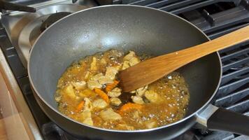 A close up of a pan cooking a savory dish with sliced chicken, vegetables, and spices, ideal for Asian cuisine enthusiasts and home chefs video