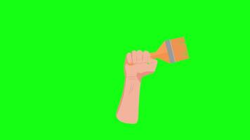 A hand holding a paintbrush on a green screen video