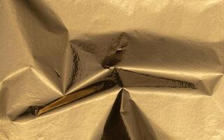 Golden foil texture with a glossy, metallic finish, creating a rich, premium backdrop. Grungy, sleek photo