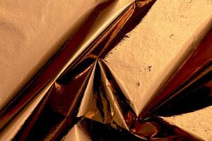 Golden and copper foil texture with a glossy, metallic finish, creating a sleek, modern backdrop. photo