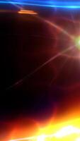 Rotating light beams generating vibrant blue and orange flares, creating dynamic visual display with glowing, shimmering optical effect against dark background. video