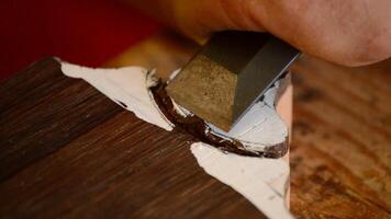 Luthier working with a chisel in a mastil of guitar video