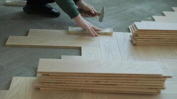 Worker installing wooden flooring with hammer and tapping block 5 video