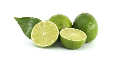 Fresh limes showing pulp and leaves on white background photo